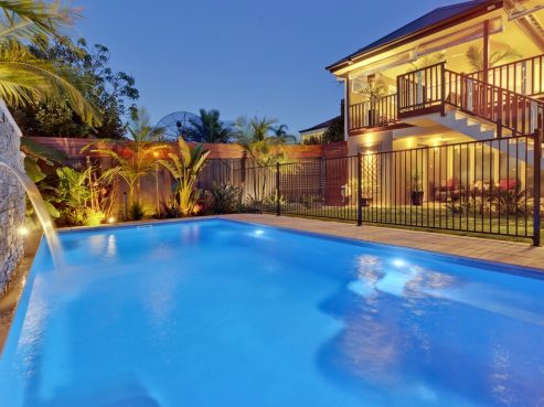 Amazing X-Trainer swimming pool with a water wall feature at night