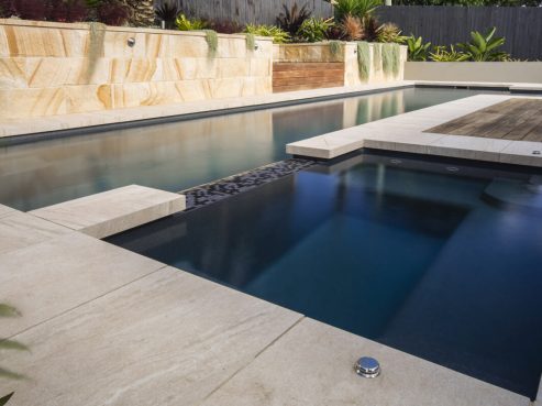 Fastlane swimming pool with spa and tropical landscaping