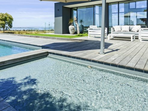 Swimming pool with a Wader attached and a timber decking